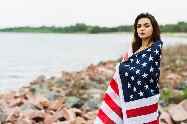 Kobieta przy morzem zakrywającym w flaga amerykańskiej