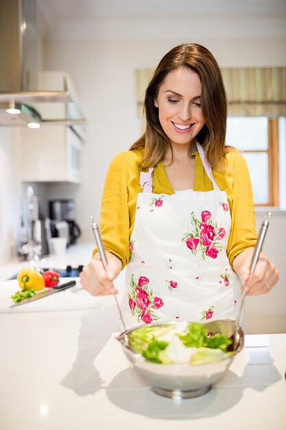 Kobieta przygotowuje sałatkę w kuchni