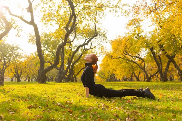 Kobieta robi joga w parku jesienią