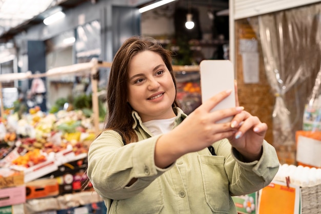 Bezpłatne zdjęcie kobieta robiąca selfie w średnim ujęciu