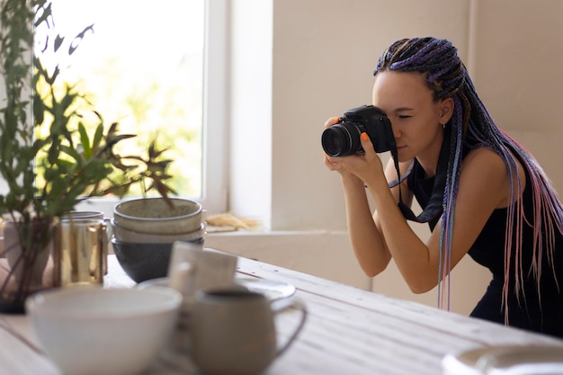 Bezpłatne zdjęcie kobieta robiąca zdjęcia ceramicznym przyborom kuchennym