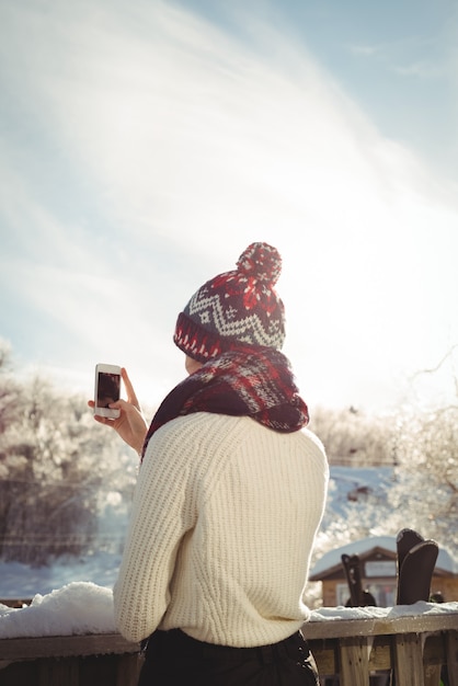 Bezpłatne zdjęcie kobieta robienia zdjęć za pomocą telefonu komórkowego w ośrodku narciarskim