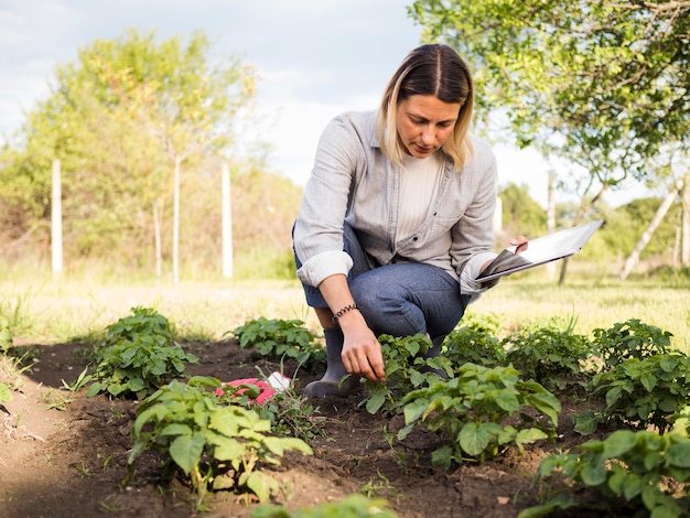 Kobieta rolnik sprawdza jej ogród