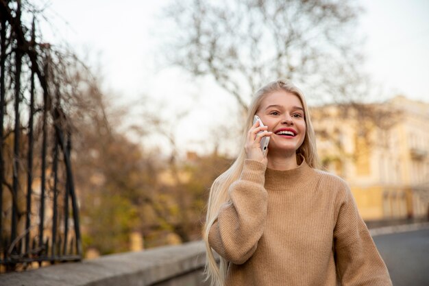 Kobieta rozmawia przez telefon średni strzał