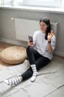 Bezpłatne zdjęcie kobieta rozmawiająca przez smartfon w domu podczas kwarantanny