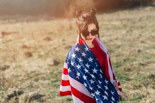 Kobieta rzuca flaga amerykańską w okularach przeciwsłonecznych
