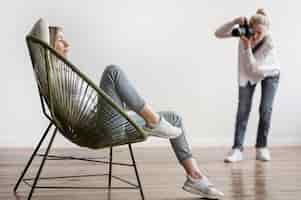 Bezpłatne zdjęcie kobieta siedzi i fotograf robienia zdjęć
