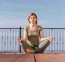Bezpłatne zdjęcie kobieta siedzi i medytuje na świeżym powietrzu