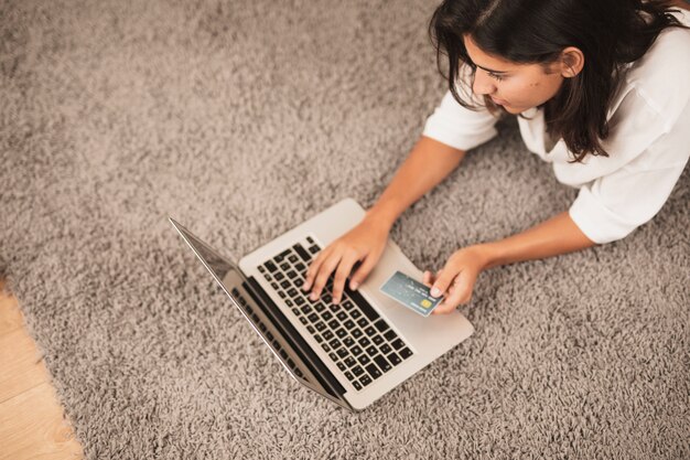 Kobieta siedzi na podłodze i pracy na laptopie