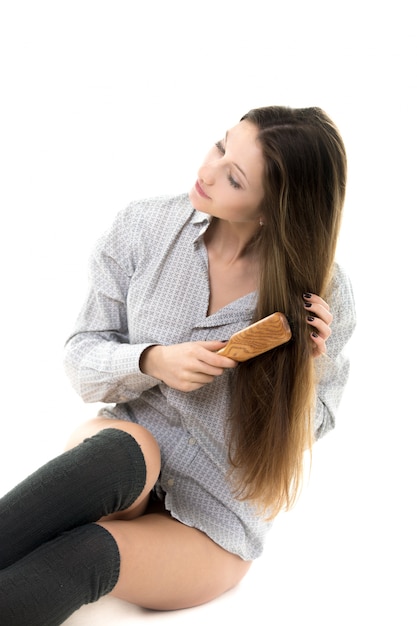 Kobieta siedzi na podłodze szczotkuje włosy