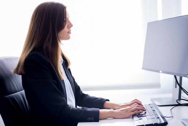 Kobieta siedzi pisania na komputerze