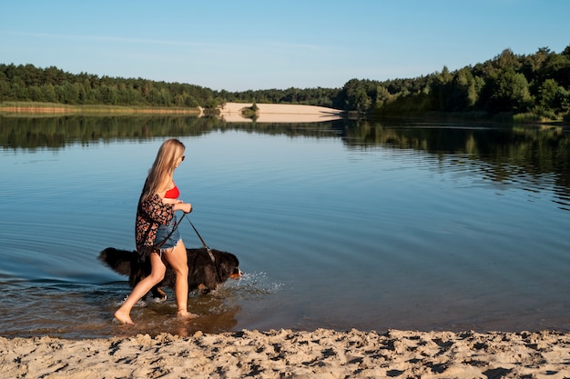 Bezpłatne zdjęcie kobieta spacerująca z psem na plaży w pełnym ujęciu