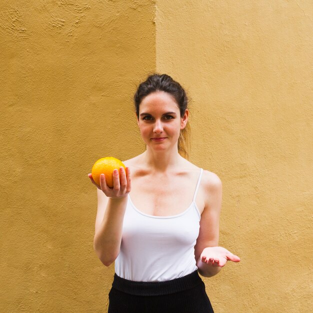 Kobieta średni strzał trzyma pomarańczy