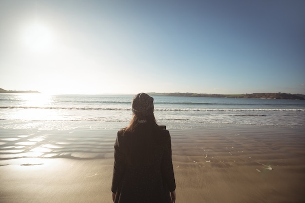 Kobieta stojąc na plaży w ciągu dnia