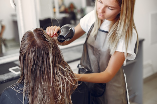 Kobieta suszenia włosów w hairsalon