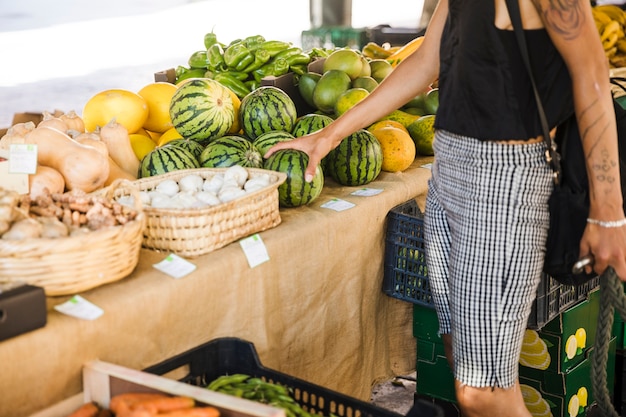 Bezpłatne zdjęcie kobieta trzyma arbuza podczas zakupu owoców na rynku