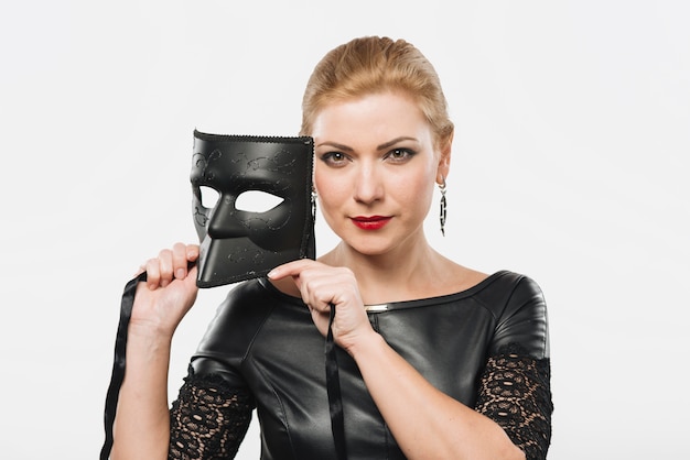 Bezpłatne zdjęcie kobieta trzyma czarną maskę w rękach