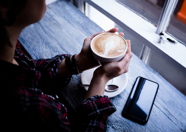 Kobieta trzyma filiżankę kawy w kawiarni