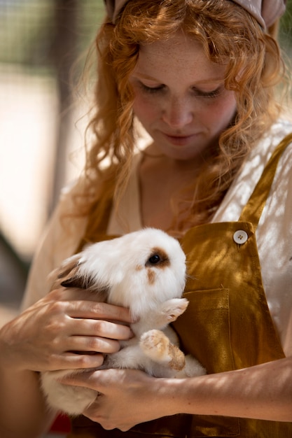 Bezpłatne zdjęcie kobieta trzyma królika z bliska