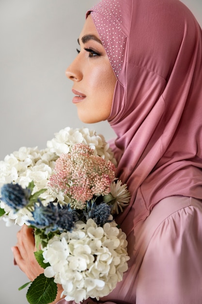 Kobieta trzyma kwiaty widok z boku