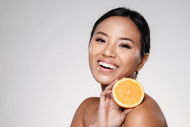 kobieta trzyma pomarańczowe plastry blisko jej twarzy