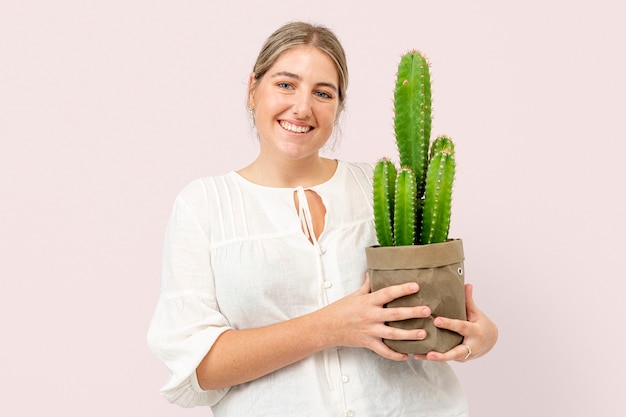 Bezpłatne zdjęcie kobieta trzymająca doniczkowy kaktus w ekologicznym opakowaniu