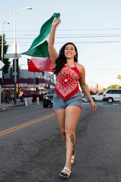 Kobieta trzymająca meksykańską flagę na ulicy