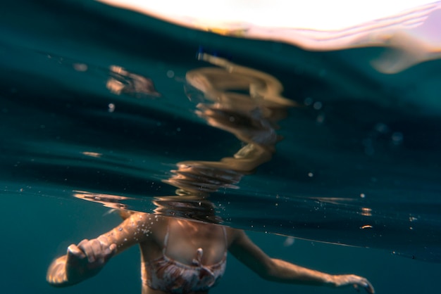 Kobieta ubrana w bikini jak pływanie w oceanie