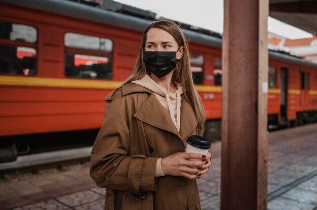 Kobieta ubrana w maskę medyczną na stacji kolejowej