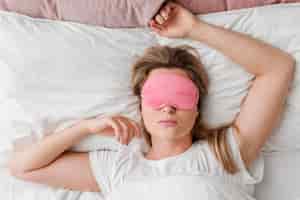 Bezpłatne zdjęcie kobieta ubrana w maskę snu na oczy