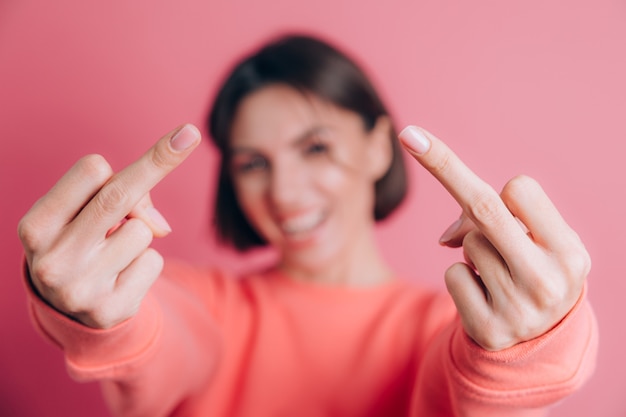 Kobieta Ubrana W Swobodny Sweter Na Tle Pokazując środkowy Palec Robi Zły Wyraz Twarzy, Prowokację I Niegrzeczną Postawę