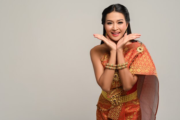 Kobieta ubrana w tajski strój, który zrobił symbol dłoni
