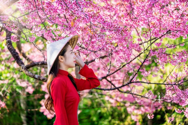Kobieta ubrana w tradycyjną kulturę Wietnamu w parku kwiat wiśni.
