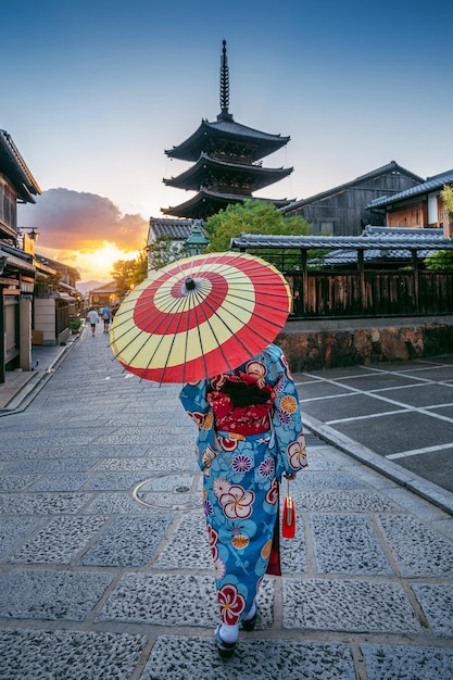 Kobieta ubrana w tradycyjne japońskie kimono z parasolem w Yasaka Pagoda i Sannen Zaka Street w Kioto, Japonia.