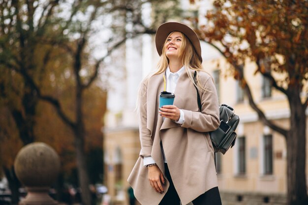 Kobieta uczeń pije kawę w kapeluszu
