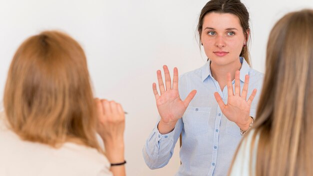Kobieta uczy języka migowego inne kobiety