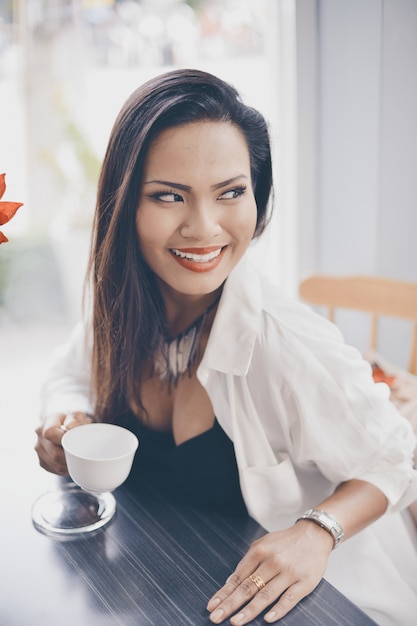 Kobieta uśmiecha o filiżankę kawy