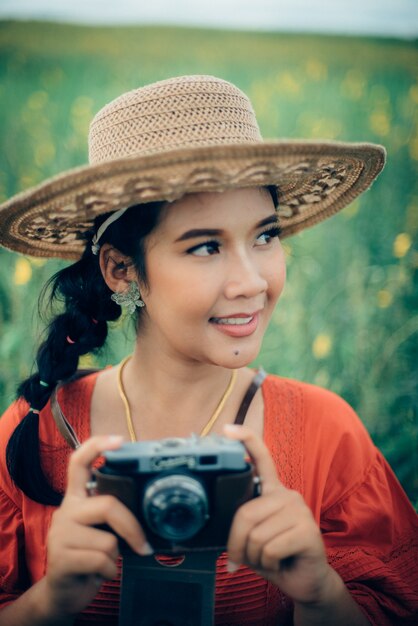 Kobieta uśmiecha się trzymając aparat fotograficzny