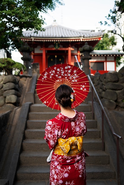 Bezpłatne zdjęcie kobieta używająca parasola wagasa widok z tyłu