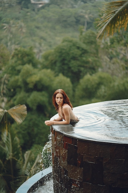 Kobieta w basenie na widok dżungli