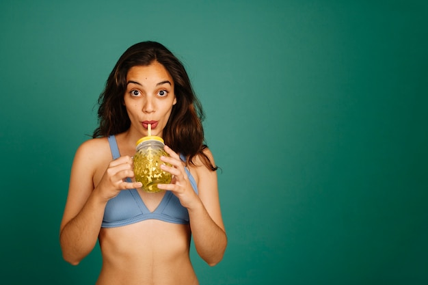 Bezpłatne zdjęcie kobieta w bikini picia soku