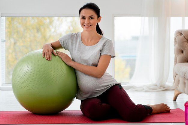 Kobieta w ciąży ćwiczy z piłką fitness