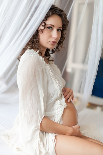 Kobieta w ciąży na sobie białe ubrania