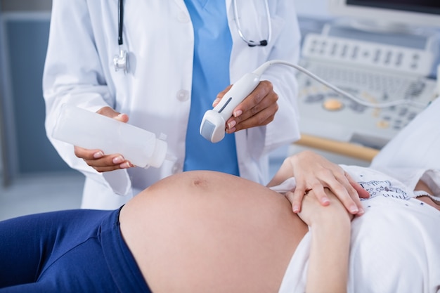 Bezpłatne zdjęcie kobieta w ciąży otrzymująca usg na brzuchu