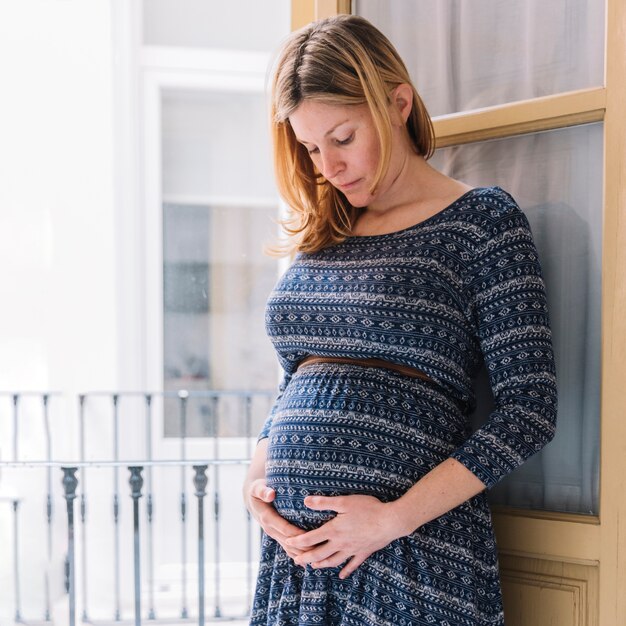 Kobieta w ciąży przed balkonem