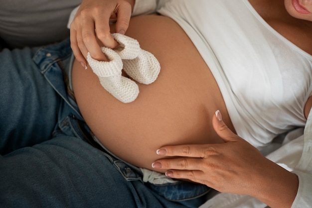 Bezpłatne zdjęcie kobieta w ciąży z wysokim kątem spędzającą czas w pomieszczeniach