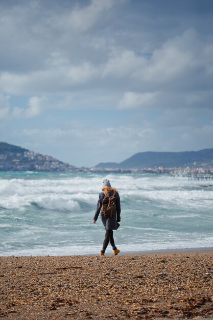 kobieta w czarnej sukni stojącej przed sein beach w ciągu dnia