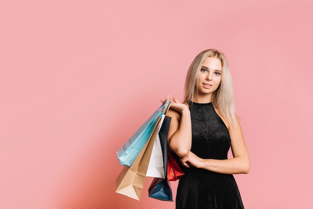 Kobieta w czarnej sukni stojącej z torby na zakupy