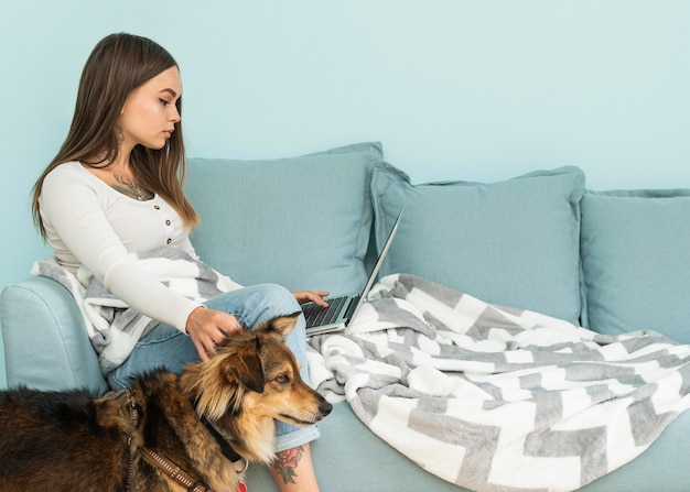 Kobieta W Domu Pracuje Na Laptopie, Pieszcząc Psa Podczas Pandemii