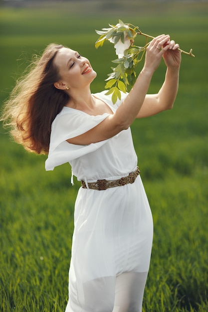 Kobieta w eleganckiej sukni stojącej w letnim polu